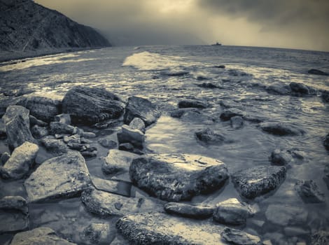 Duotone shot of stones at sea beach