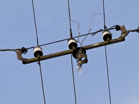 Street wires with lamp against blue sky