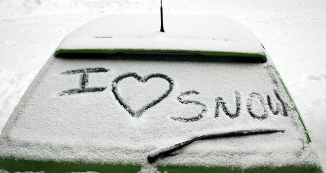 lettering of i love snow on snowy car window