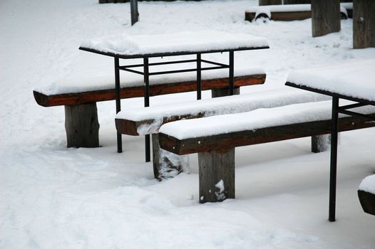 snowy bench and table in Karvina park, horizontally framed shot