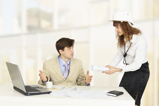 Pair of young engineers on a workplace