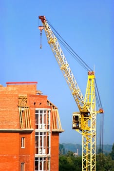 The building crane stands near a builded house