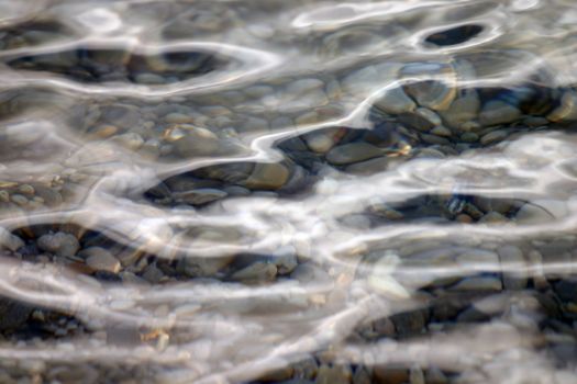 wavy water surface with pebbels