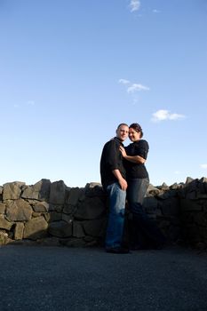 A young happy couple in a loving embrace outdoors with copy space.