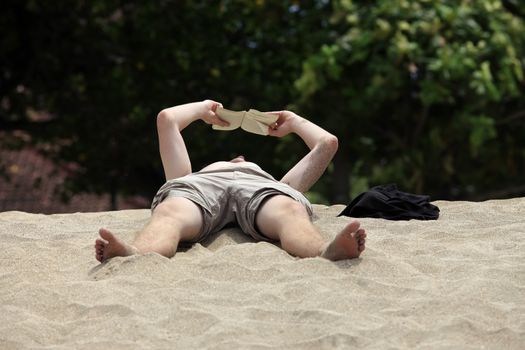 The man reads the book on a beach