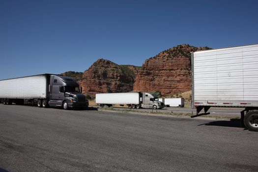 Truckers pause as traffic passes on nearby American interstate highway.