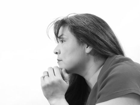 A brunette woman looks off to the side. A very thoughtful look on her face. In black and white on an isolated white background.