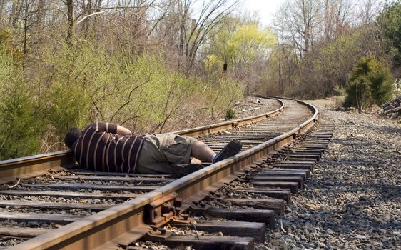 A man laying on the railroad tracks. Not exactly the smartest thing to do.