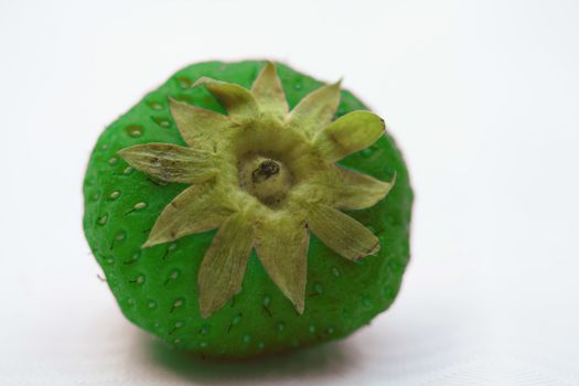 A close up of a fresh green strawberry