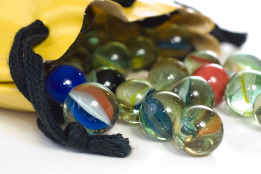 Closeup view of a bag of marbles, shot against a white background