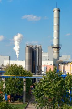 Factory pipes with a smoke on a background of the dark blue sky.
