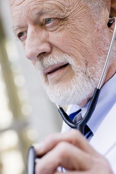 Profile of an Old Male Doctor Listing to a Stethoscope