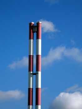 Equal striped pipe on a background of blue sky with clouds