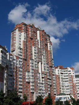 Beautiful red house on a background of blue sky with clouds