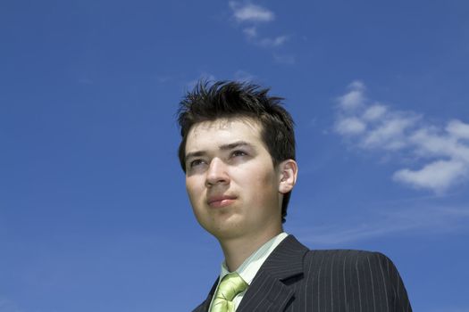 Portrait of happy young man on blue sky background; copy space