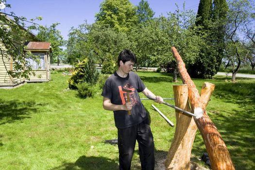 Young man in a garden does a balance swing