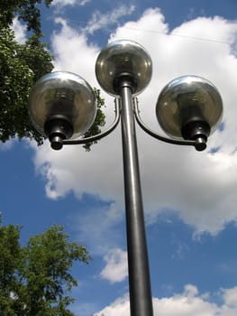 Flashlight with three nice sphere lamps on a background of blue sky with clouds