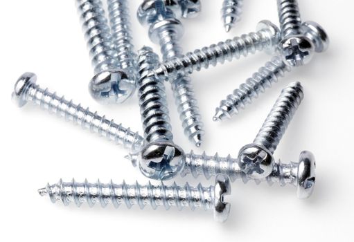 Macro Close-Up Of Spiral Metal Screws On A White Background