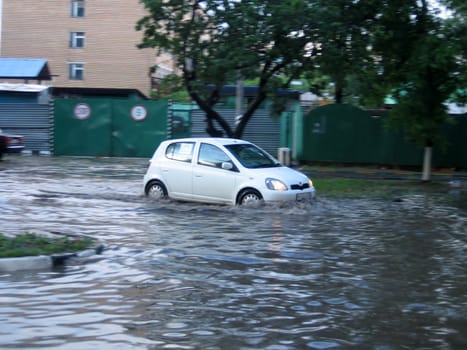 Small white car move at the water street