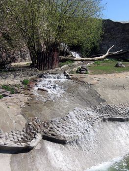 Small quick waterfall lowers downwards on stones