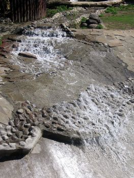 Small quick waterfall lowers downwards on stones
