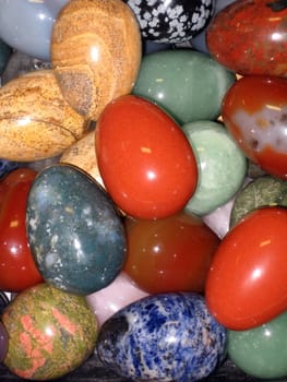 Various colour stones like an egg are on a background