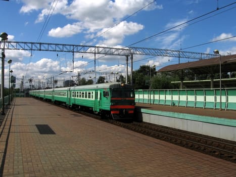 Green fast Russian train moves to the station