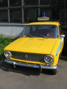 Yellow police old car near the museum, sunny photo
