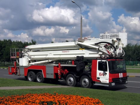 Very beautiful long fire truck in Moscow on a background of gray clouds