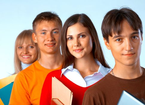  Casual group of college students smiling stand in a row with books on white 