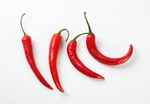 Perfectly fresh red hot peppers on white.  Professionally retouched high quality image.