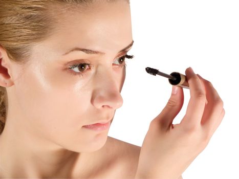 young woman putting make up on her face. Isolated