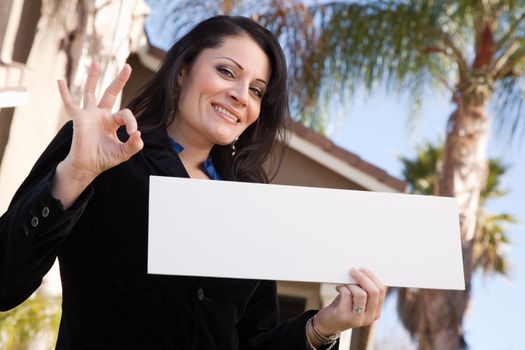 Happy Attractive Hispanic Woman Holding Blank Sign in Front of House.