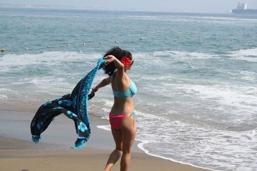 Young Latin woman sitting on beach