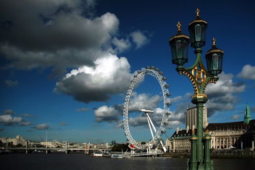 London eye with river, dark blue sky and white cloud