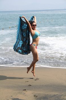 Young Latin woman sitting on beach