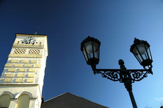 white clock tower, black light and blue sky, horizontally framed shot