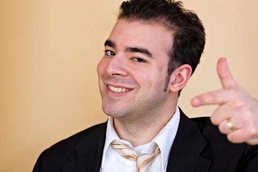 A goofy smiling business man pointing and trying to act like he is a cool guy.  Shallow depth of field with focus on the face.