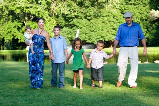 An attractive young family walking together through the park on a nice spring or summer day.