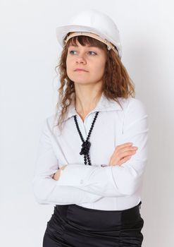 The serious young woman the engineer - builder in a white helmet