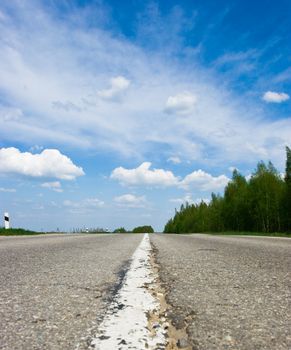 Open road against blue sky with clouds