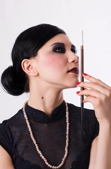 Retro styled thoughtful girl with cigarette holder