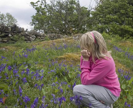 Young girl smelling the flowers.