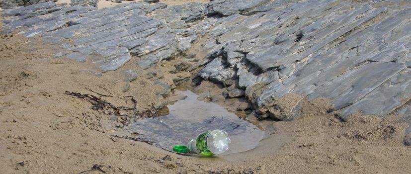 Abandoned pop bottle left on the beach