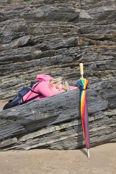  Teenage girl relaxes in the sunshine,with an umberella cover at hand. 