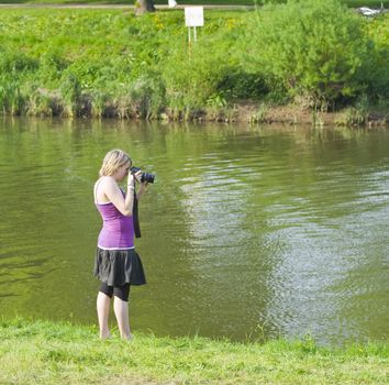 Teenage girl photographs by the river Severn