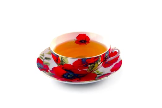 The beautiful cup of tea on a plate is photographed close up on a white background