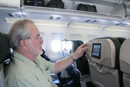 Man on airplane looking at inflight tv