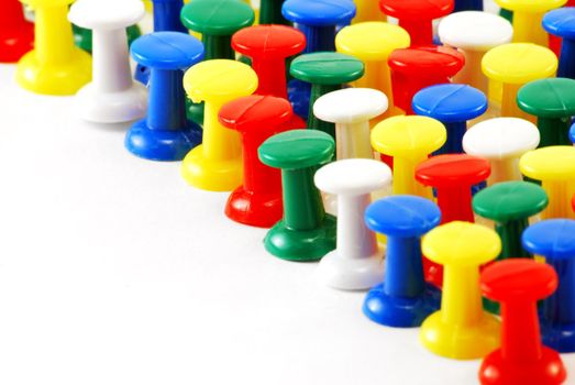 Many drawing-pins are photographed close up on
white background