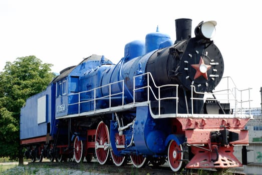 The ancient steam locomotive stands on a pedestal